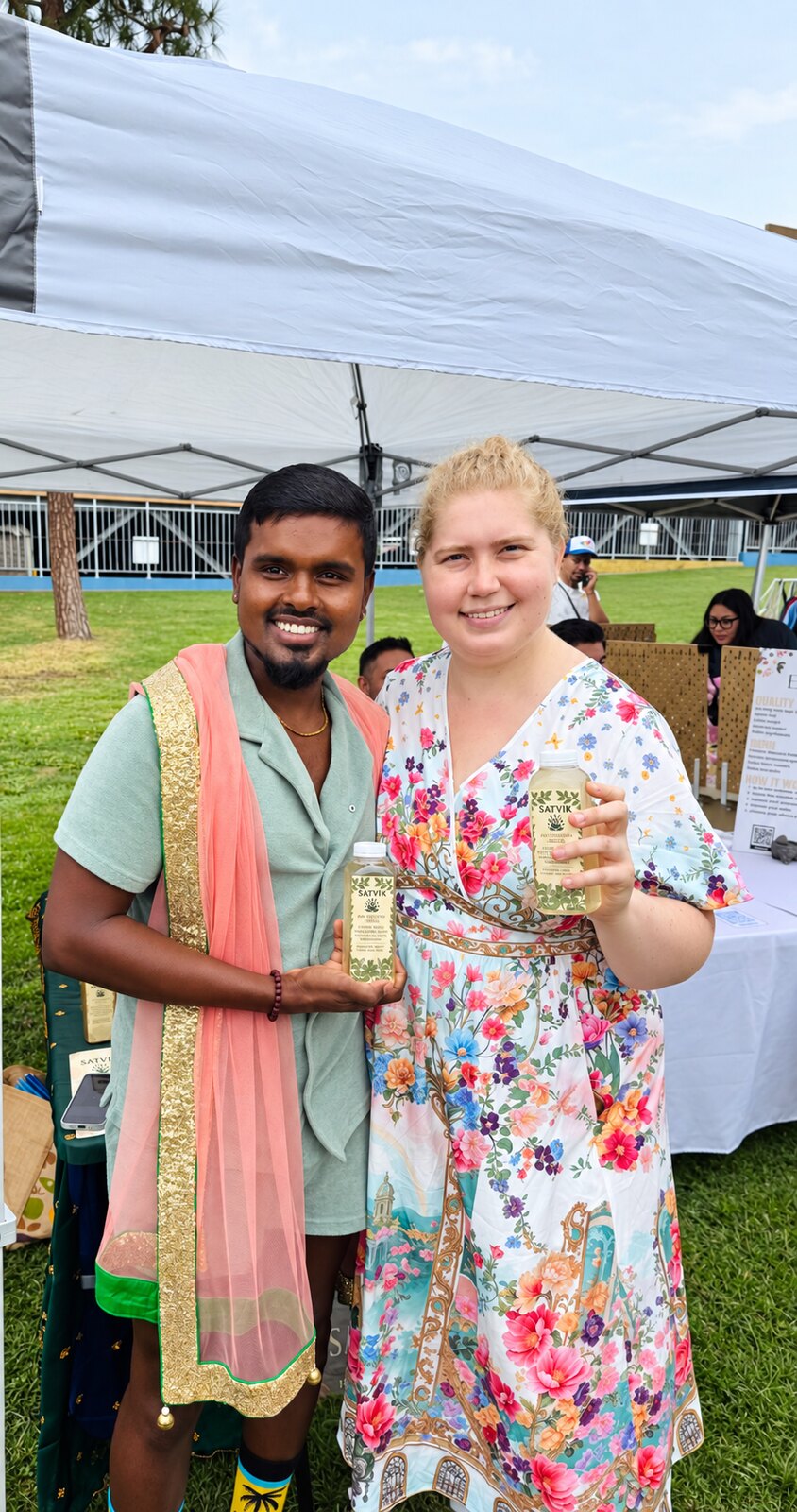 A farmers-market guest holding Satvik herbal waters with the founder