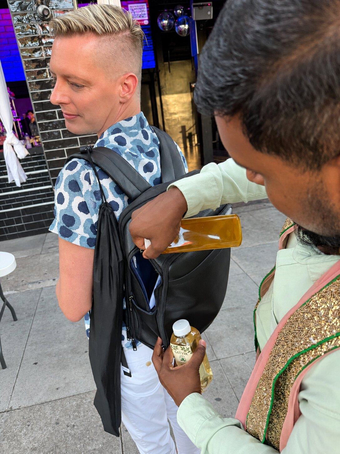 Sharing bottles of Satvik herbal water with a community guest
